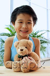 AsiaPix - Young girl holding teddy bear, smiling at camera