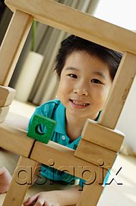 AsiaPix - Young girl playing with building blocks, looking at camera