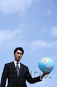 AsiaPix - Businessman holding globe, looking at camera
