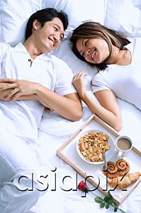 AsiaPix - Couple lying on bed, breakfast on tray next to them