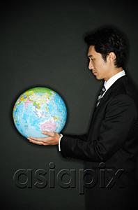AsiaPix - Businessman looking at globe in hands