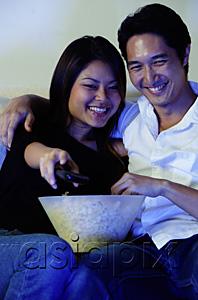 AsiaPix - Couple watching TV, woman holding remote control