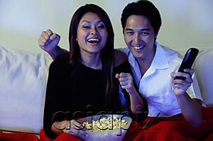 AsiaPix - Couple watching TV, making fists, smiling