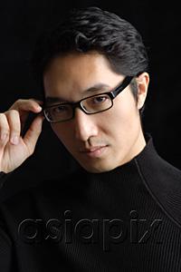 AsiaPix - Man adjusting glasses, portrait