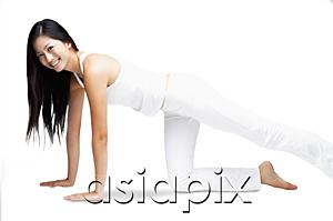 AsiaPix - Woman kneeling on floor, stretching leg, smiling at camera