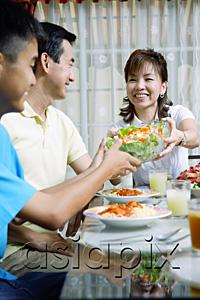 AsiaPix - Mother passing salad bowl to family members