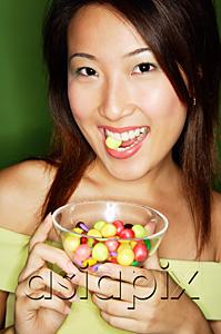 AsiaPix - Woman eating candy and holding candy bowl
