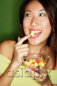 AsiaPix - Woman with bowl of candy, putting candy into mouth