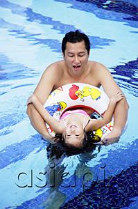 AsiaPix - Father and daughter in swimming pool, daughter using inflatable ring