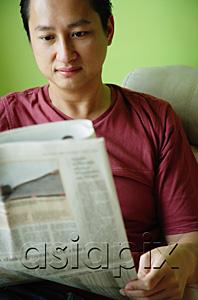 AsiaPix - Man sitting, reading newspaper
