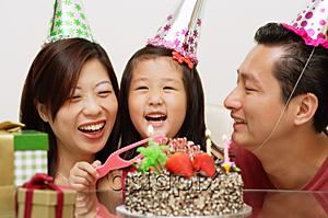 AsiaPix - Girl with birthday cake, parents on either side smiling