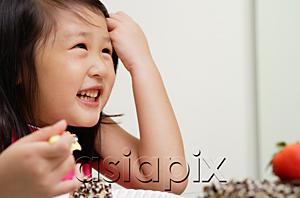 AsiaPix - Young girl pulling hair back from face, smiling