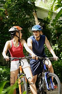 AsiaPix - Couple riding bikes and smiling, looking at each other
