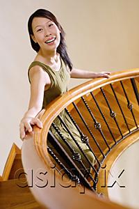 AsiaPix - Woman standing on staircase, looking at camera
