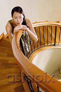 AsiaPix - Woman on staircase, leaning on banister, looking at camera