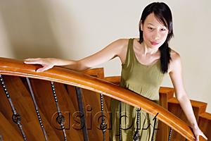AsiaPix - Woman standing on staircase, hands on banister