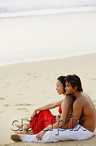 AsiaPix - Couple sitting on beach, looking at sea