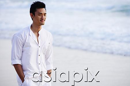 AsiaPix - Man standing on beach, hands in pocket