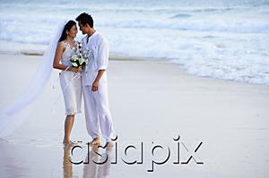 AsiaPix - Bride and groom on beach, standing face to face