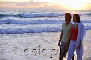 AsiaPix - Couple walking on beach, during sunset, holding hands