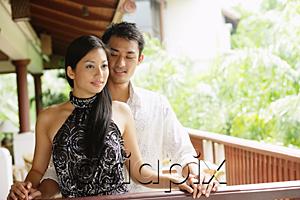 AsiaPix - Couple standing together next to railing, man behind woman