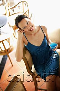 AsiaPix - Woman sitting on bar stool, holding drink, smiling at camera