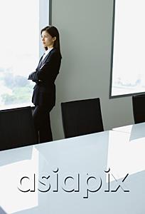 AsiaPix - Businesswoman standing next to window in conference room