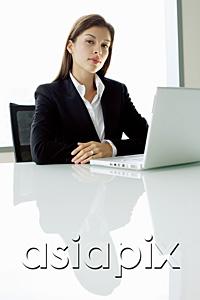 AsiaPix - Businesswoman sitting at table, with laptop