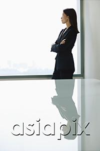 AsiaPix - Businesswoman standing with arms crossed, looking at window