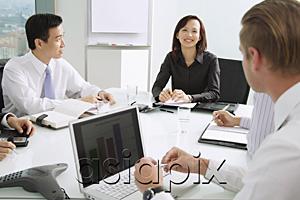 AsiaPix - Businesswoman at head of table, smiling, male executives sitting around her