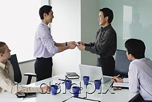 AsiaPix - Executives in meeting room, exchanging business cards
