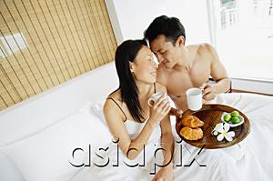 AsiaPix - Couple having breakfast in bed, sitting face to face