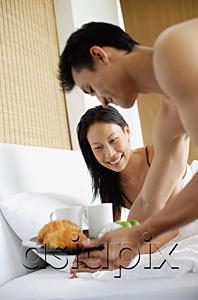 AsiaPix - Woman in bed, man bringing breakfast tray