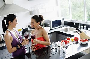 AsiaPix - Two women standing in kitchen, holding wine glasses
