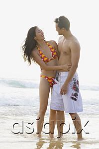 AsiaPix - Couple on beach, embracing, looking at each other