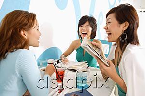 AsiaPix - Young women in cafe, talking over drinks