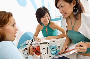 AsiaPix - Young women talking over drinks in cafe