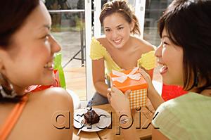 AsiaPix - Young women at home, one holding gift