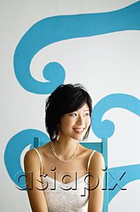 AsiaPix - Young woman sitting on chair, looking away