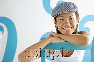 AsiaPix - Young woman wearing beret, leaning on chair, looking at camera