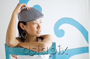 AsiaPix - Young woman wearing beret, looking away, hand on head