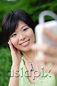 AsiaPix - Young woman with mp3 player, smiling