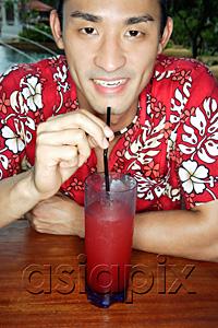 AsiaPix - Man wearing floral shirt, having a drink, looking at camera