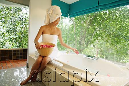 AsiaPix - Woman in towel, sitting at edge of bath tub, throwing flower petals into tub