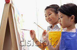 AsiaPix - Young girls standing side by side, painting on easel