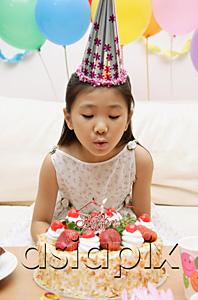 AsiaPix - Girl blowing out candle on a cake