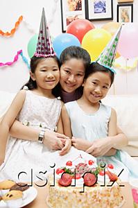 AsiaPix - Mother with two girls celebrating a birthday, smiling at camera