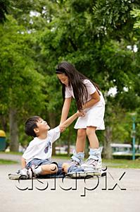 AsiaPix - Children rollerblading, boy on the ground, girl pulling him up
