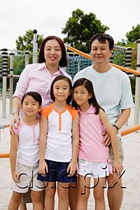AsiaPix - Family standing at playground, smiling at camera