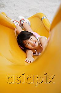 AsiaPix - Girl on slide, smiling up at camera, high angle view